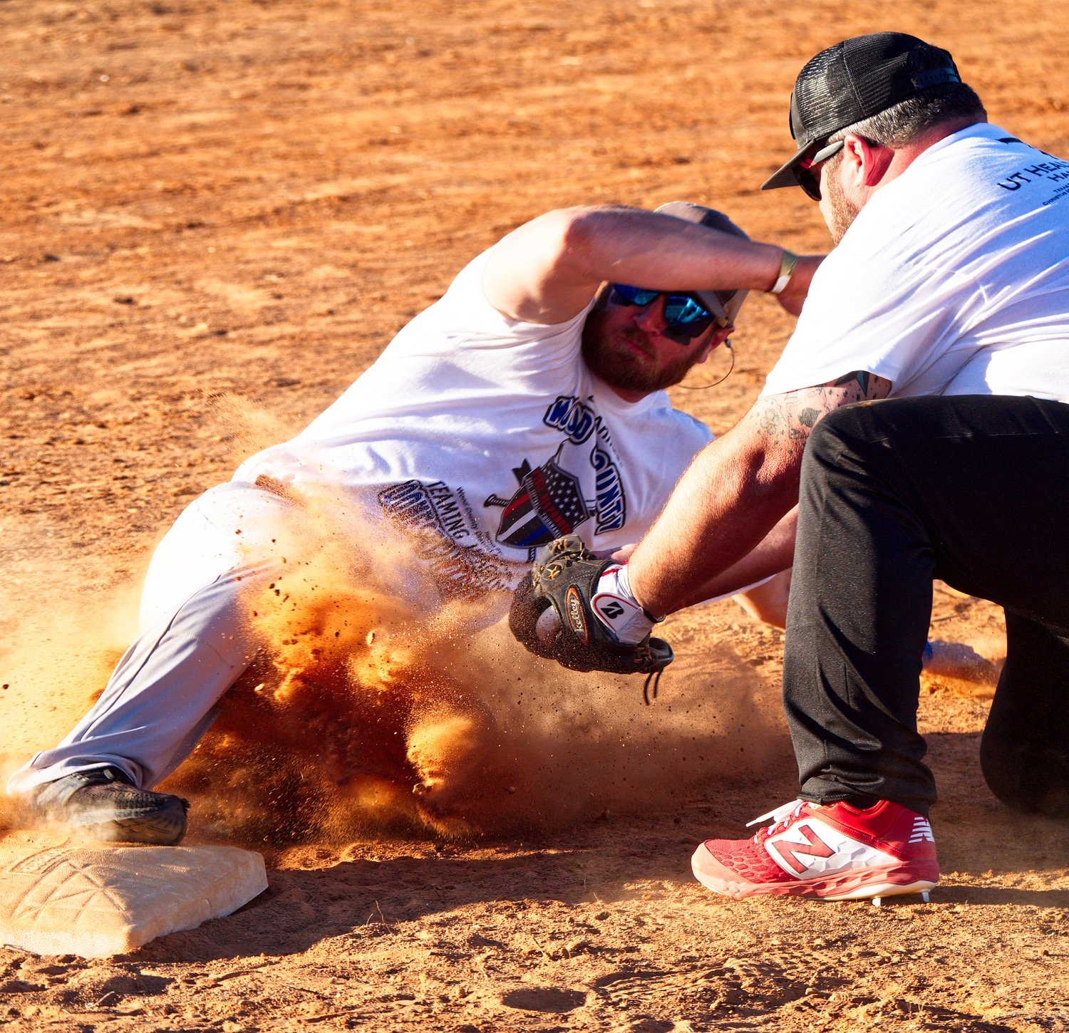 Jeremy Ragsdale slides under tag of Josh Hearn at 3rd base during the championship game of the first responders softball tournament Saturday in Quitman. [See action from the games.]